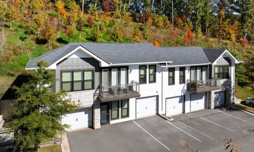 exterior of building with green turf and some seating