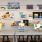 a art room with a table and chairs with a wall of posters on the wall