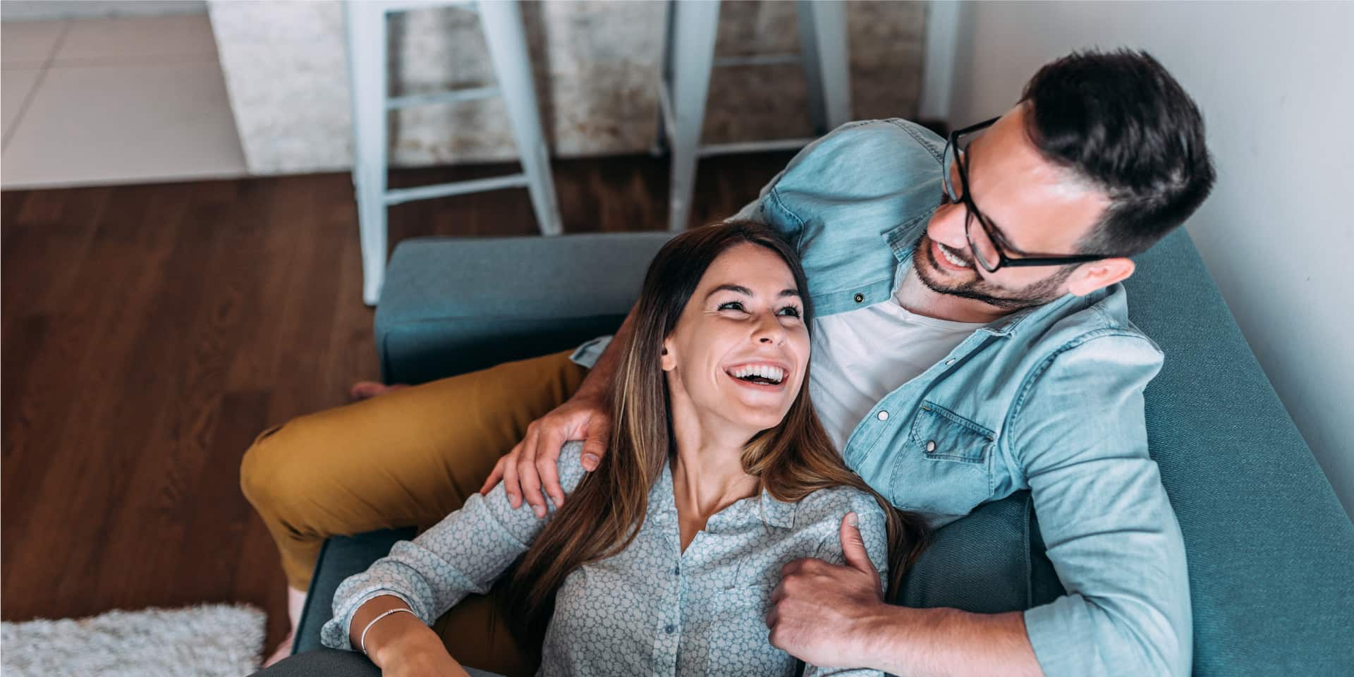 Couple sitting on couch laughing